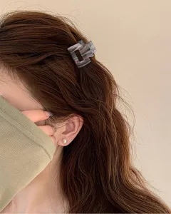 Vista ravvicinata di un mini fermaglio per capelli chic con un elegante motivo retro.