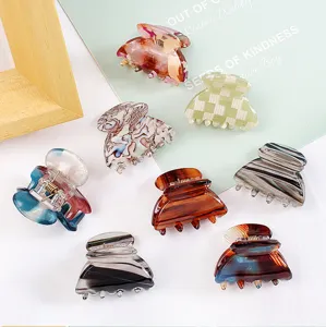 Vue de détail de diverses pinces à cheveux miniatures assorties avec motifs marbrés.
