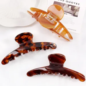 Detailed shot of acetate hair claws, tortoise shell and amber large clip set for chic styling.