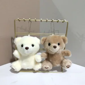 Gedetailleerde close-up van schattige pluche beren sleutelhangers met ketting op een standaard.