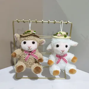 Close-up of cute plush sheep keychains with straw hats and bows, hanging display detail view.