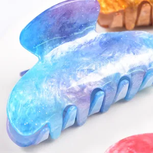 Pinza per capelli in acrilico stellato blu, dettaglio con superficie glitterata e denti.