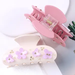 Elegante detalle de pinza de pelo de acrílico con pedrería brillante y bonitos detalles florales.