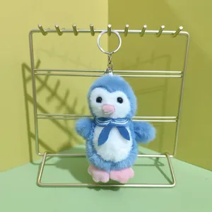 Close-up of cute blue plush penguin keychain with sailor scarf and metal ring detail.