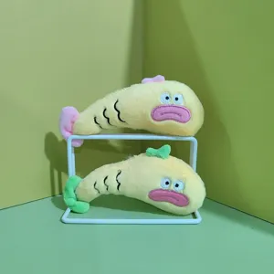 Detailaufnahme von niedlichen Plüschfischen mit weichem gelbem Stoff und gestickten Gesichtern.