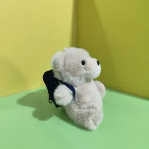 Detailansicht des niedlichen kleinen Teddybär Plüschtiers mit einem blauen Mini-Rucksack.