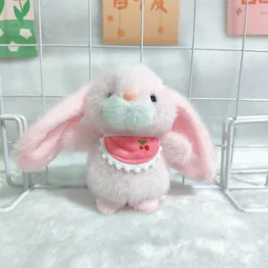 Close-up van schattige roze hangende pluche konijnenknuffel met kersensabbelbib.