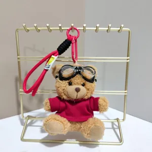 Cute plush pilot bear keychain with goggles, red shirt, and lanyard. Perfect bag charm.