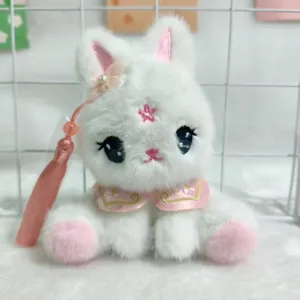 Nahaufnahme des süßen chinesischen weißen Plüschhasen-Anhängers mit rosa Blume und Quaste.