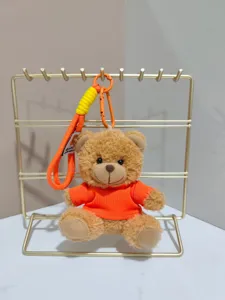 Cute teddy bear plush keychain backpack ornament, soft brown toy with orange shirt and strap.