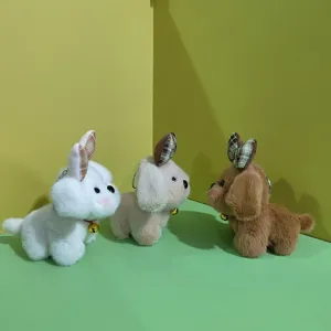 Dettaglio portachiavi peluche cucciolo con orecchie a quadri e campanello dorato.