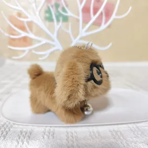 Detailopname van schattige pluizige puppy pluche sleutelhanger met een ronde bril.