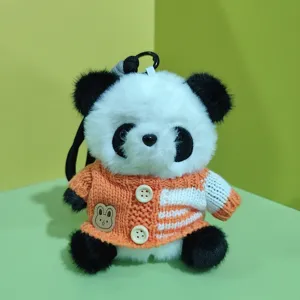Plush panda keychain detail view, cute stuffed animal toy with orange knit sweater charm.