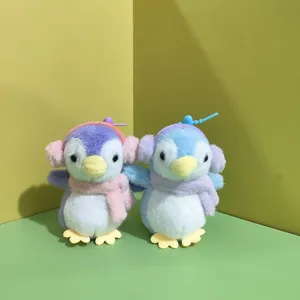 Primo piano di simpatici giocattoli di pinguini di peluche con cuffie e sciarpe colorate.