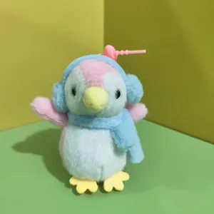 Dettaglio ravvicinato del simpatico ciondolo pinguino di peluche con tessuto morbido e paraorecchie.