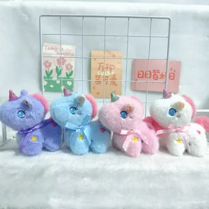 Dettaglio peluche ciondolo unicorno con quattro giocattoli colorati con corna glitterate e fiocchi.