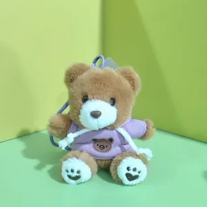 Cute plush teddy bear keychain detail, soft stuffed animal toy pendant with purple hoodie.