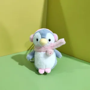 Dettaglio peluche pinguino carino con paraorecchie e sciarpa rosa portachiavi.