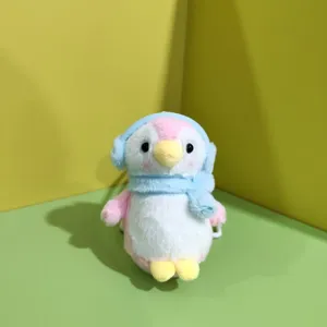 Dettaglio del ciondolo peluche pinguino carino con paraorecchie e sciarpa morbida.