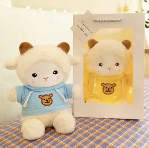 Simpatico giocattolo di peluche di pecora con felpa con cappuccio blu e confezione regalo.