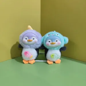 Cute plush penguin pendant detail shot showing vinyl silicone face and fluffy body with fish decor.