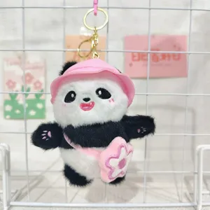Niedlicher Plüsch-Panda-Schlüsselanhänger mit rosa Sonnenhut und Blütentasche im Detail.