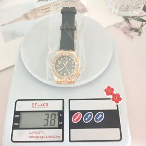 Vue détaillée d'une montre à quartz avec lunette strass et bracelet sur balance numérique.