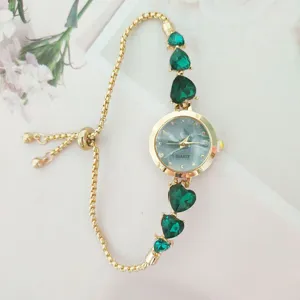 Elegant gold quartz watch with green heart crystal charms and adjustable sliding chain.