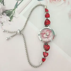 Women quartz watch with red heart crystal charm, pink dial and adjustable pull bracelet.