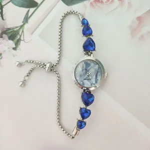 Detail view of a women's quartz bracelet watch with blue heart rhinestones and pull chain.
