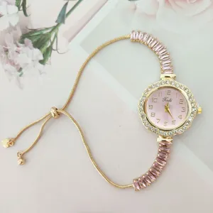 Elegante reloj de cuarzo dorado para mujer con esfera rosa y pulsera deslizante.