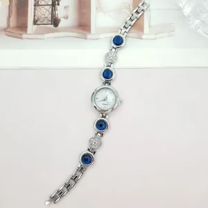 Damen Luxus Quarz Armbanduhr mit blauen Kristallen und funkelnden Strasssteinen.