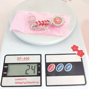 Gedetailleerd overzicht van strass blad quartz horloge op weegschaal voor gewicht.