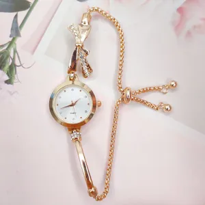Rose gold quartz watch detail featuring a sparkling rhinestone bow and adjustable chain strap.