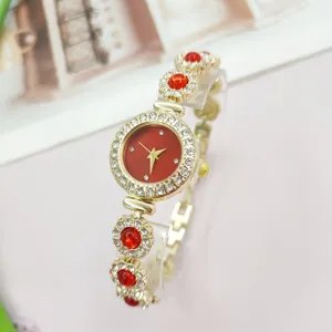 Rote Damen Strass Quarz Uhr Detailansicht, elegantes goldenes Metallarmband Schmuck.