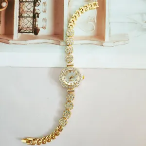 Elegant gold rhinestone flower quartz watch detail view showcasing sparkly crystal details.