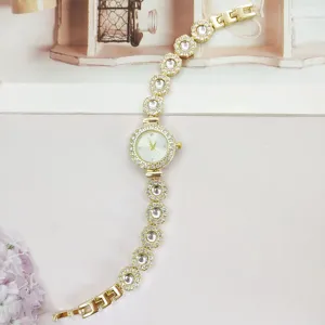 Exquisites Detail der goldenen Damenuhr mit funkelnden Strasssteinen und Armbanddesign.