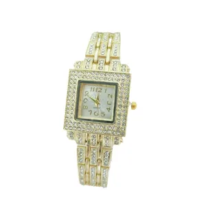 Close-up of luxury gold square rhinestone watch, featuring sparkling dial numbers and crystal stones.