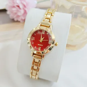 Vue détaillée de la montre quartz femme de luxe dorée avec cadran rouge et bracelet chic.