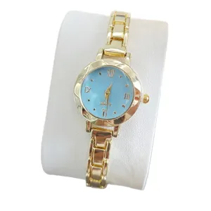 Vue de détail de la montre à quartz dorée élégante avec cadran bleu clair et bracelet en métal.