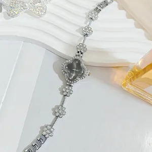 Silver rhinestone clover quartz watch with floral bracelet strap, elegant detail view.