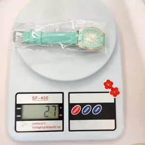 Detailansicht der mintgrünen Damen-Armbanduhr auf einer modernen digitalen Waage, 27g.