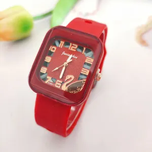 Red silicone strap square watch dial detail showcasing elegant gold digits and swan design.