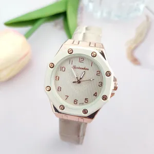 Primo piano dettagliato di un elegante orologio da donna al quarzo oro rosa con lunetta bianca.