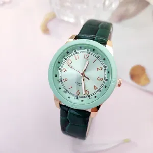 Minimalistische mintgrüne Damen Quarzarmbanduhr mit dunklem Lederarmband und Ziffernblatt.