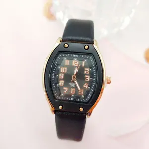Nahaufnahme der Damen Tonneau Quarzuhr mit schwarzem Armband und goldenen Gehäusedetails.
