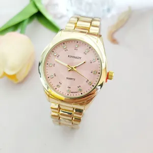 Detail view of a luxury gold quartz watch with pink diamond dial and steel strap.