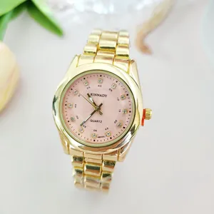 Close-up view of gold quartz watch detail featuring pink dial and rhinestone markers.