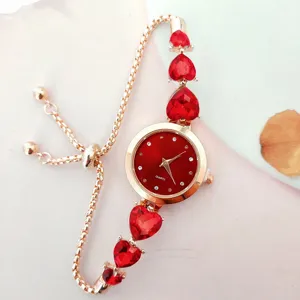 Rote Herz Kristall Quarz Uhr Detail mit elegantem Roségold Schiebearmband Design.