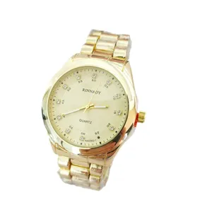 Golden quartz watch detail showing the metallic strap, elegant dial, and sparkling rhinestones.